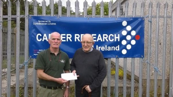 Tommy McGrath presents a cheque for �315 to William Quigley of Cancer research N I.